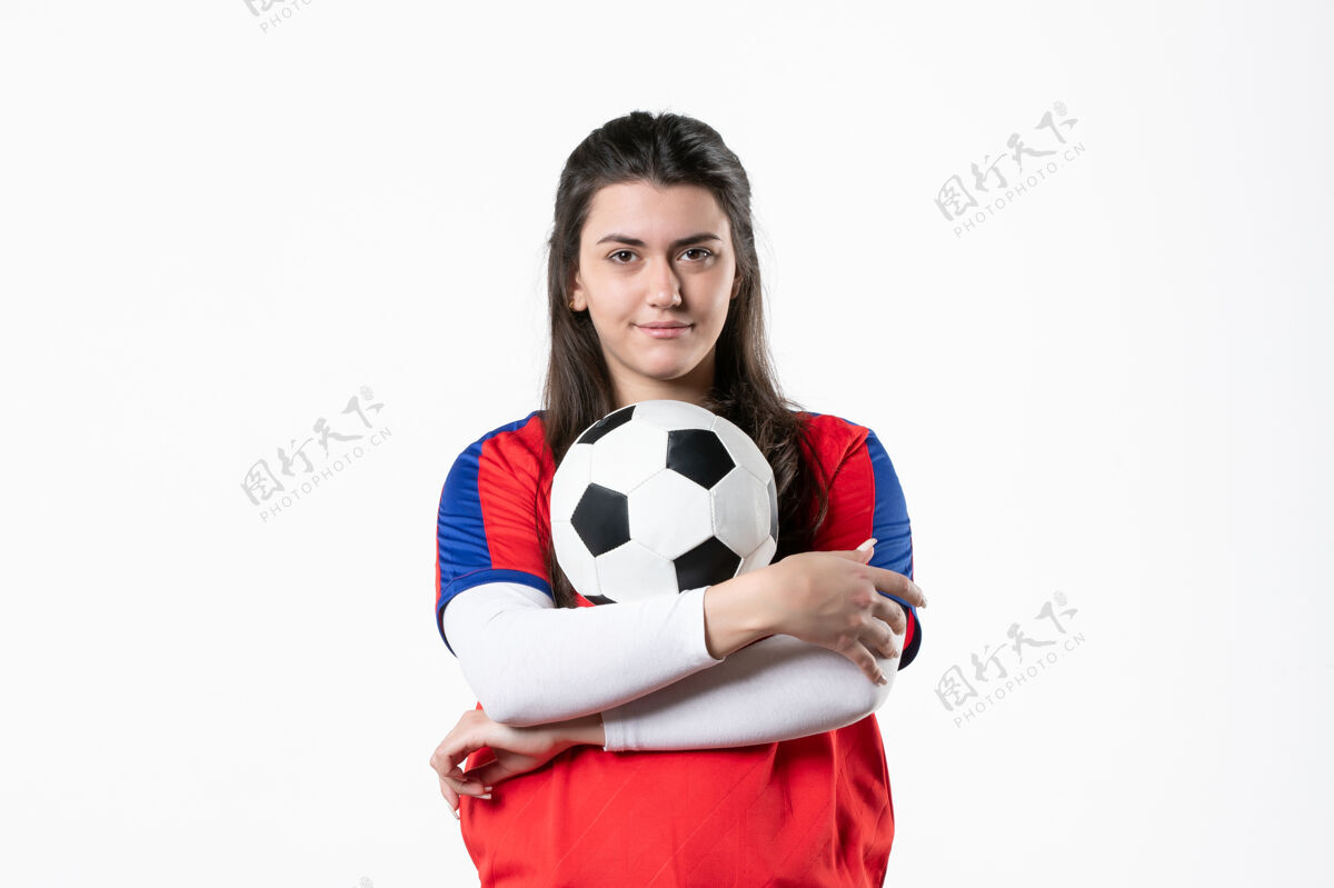 人前视图穿着运动服的年轻女性 白色墙壁上有足球前面人视图