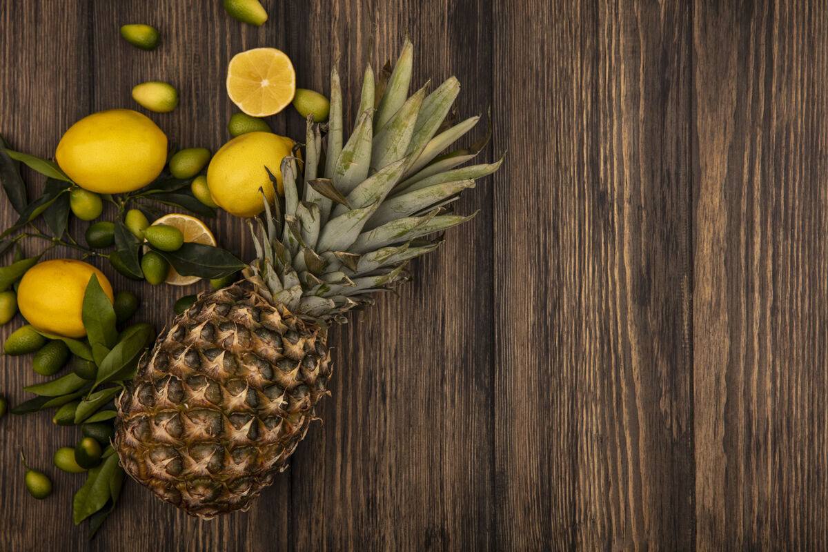 饮食顶视图不同的新鲜水果 如菠萝柠檬和金盏花隔离在一个木制墙壁与复制空间素食新鲜顶部