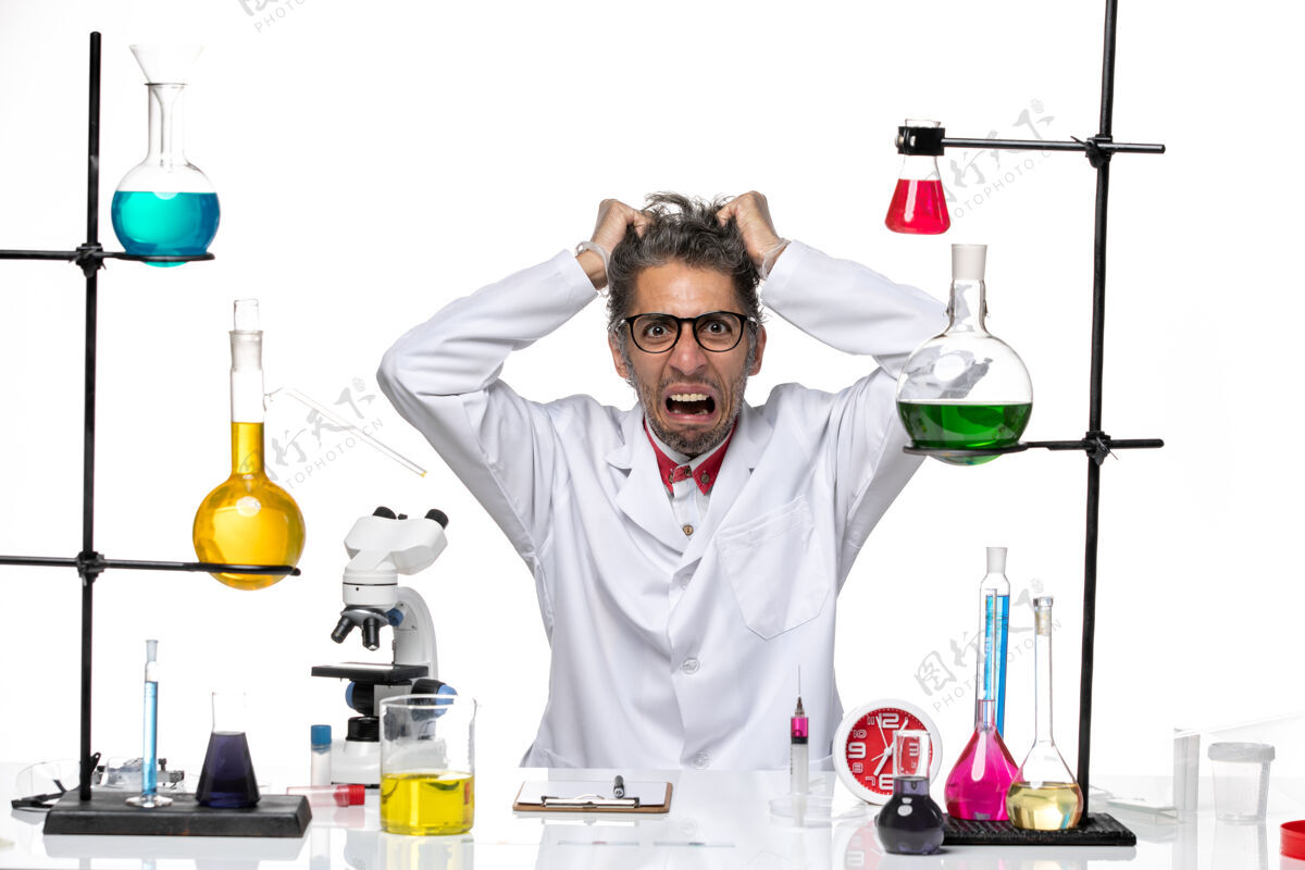 化学前视图穿着医疗服的中年科学家坐着扯头发观点男性实验室