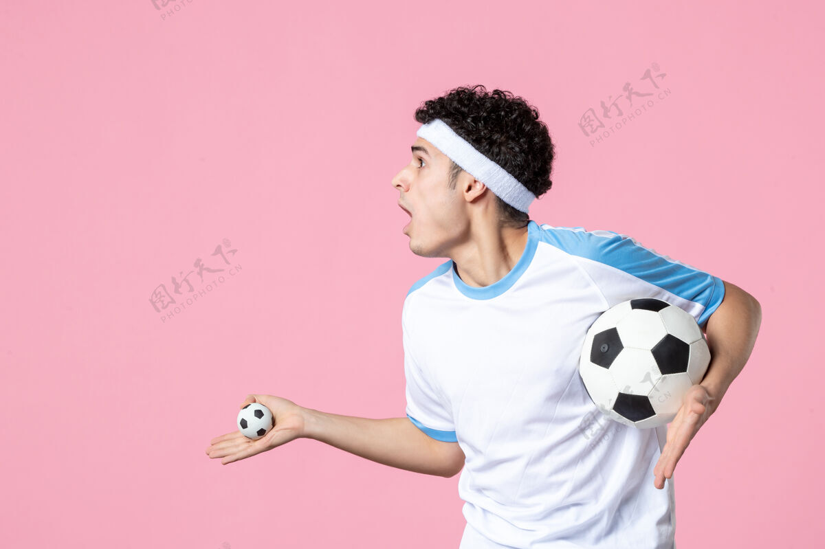 粉红前视图兴奋的足球运动员在运动服与球人视图球
