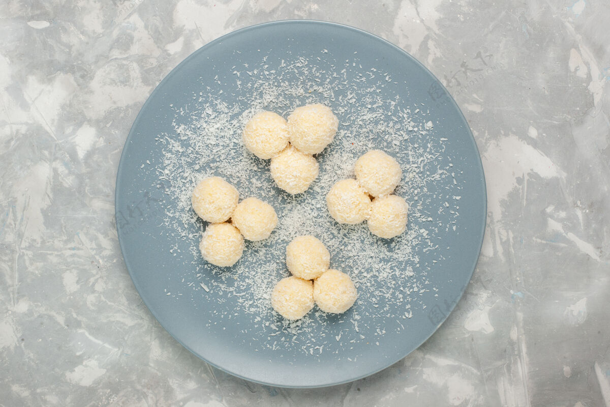 面团白色表面上美味的椰子糖甜球俯视图生的豆类球
