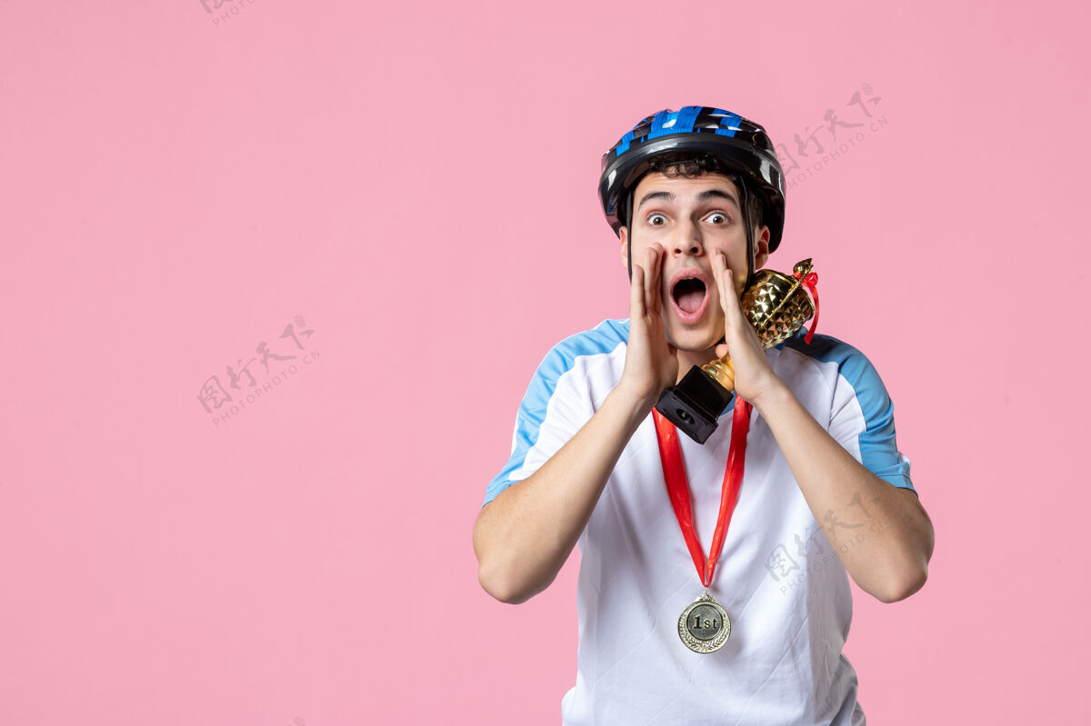自行车正面图身着运动服手持头盔金杯的男运动员耳语金色赛车水平