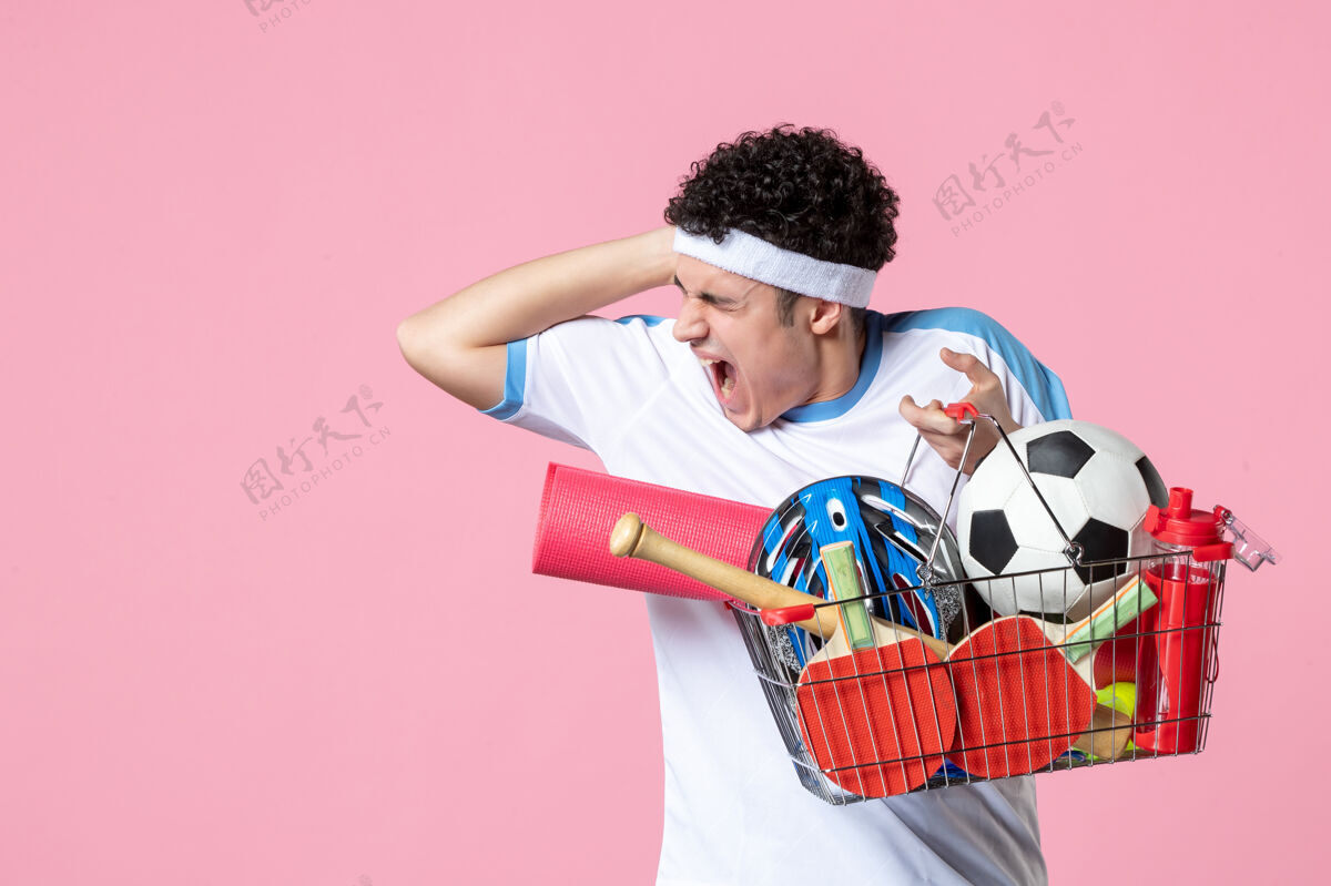 前面前视图尖叫的年轻男子穿着运动服 篮子里装满了运动用品东西男孩男性