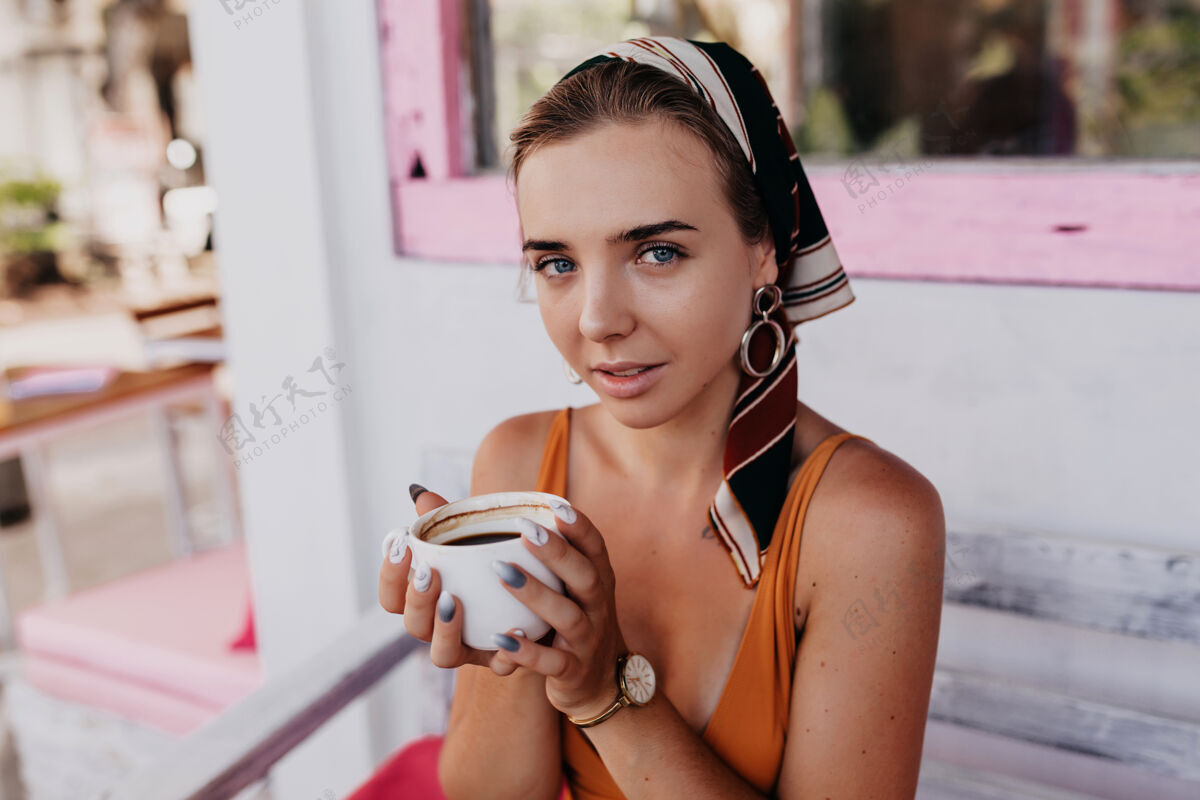 散步可爱女人的特写肖像 头上戴着配饰 一边拿着咖啡 一边在外面吃早餐健康时尚欢笑