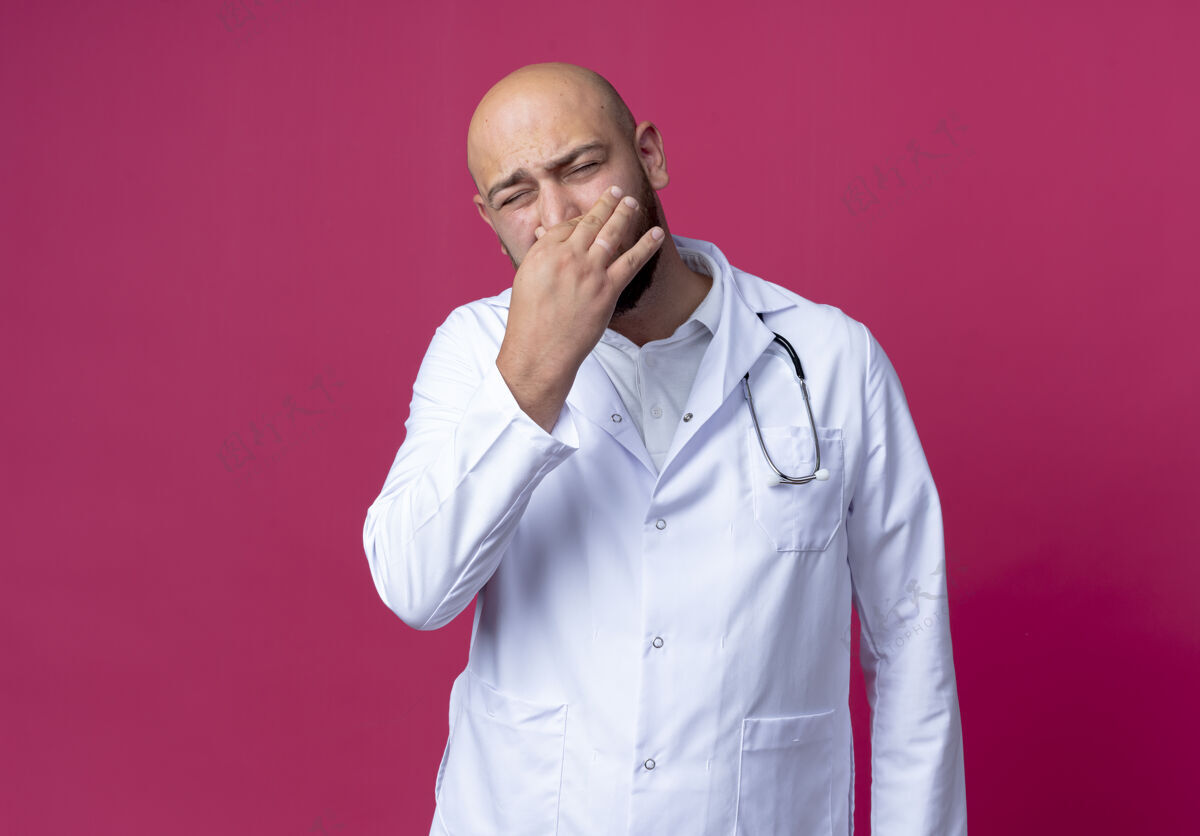 粉红色闭着眼睛 一个穿着医用长袍 神经质的年轻男医生听诊器长袍医学