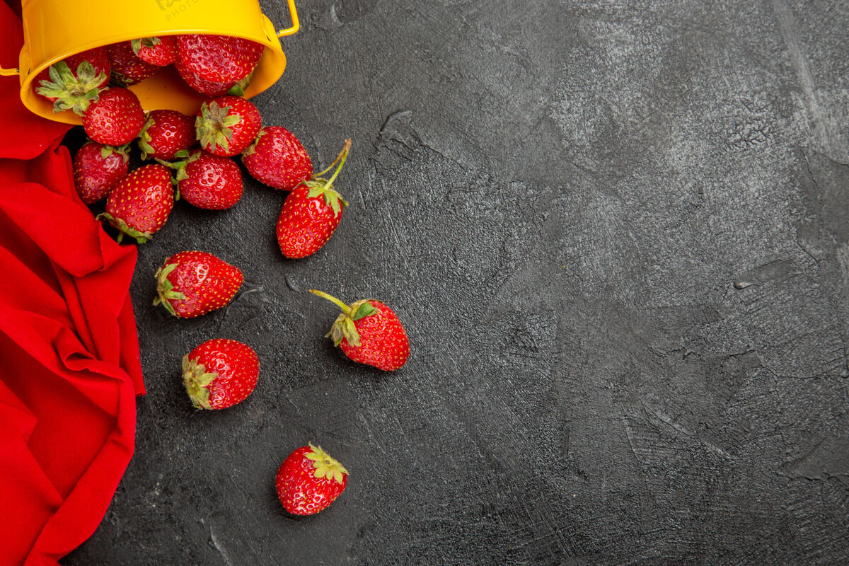 深色顶视图新鲜的红色草莓放在深色的桌子上 水果浆果成熟了健康美味顶视图