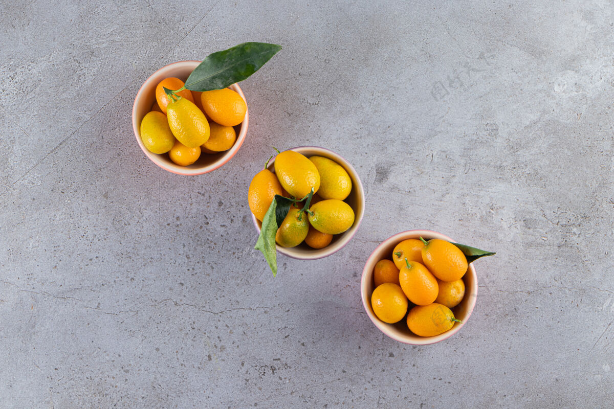 多新鲜的全柑橘类金橘果实 叶子放在碗里金橘堆的金色