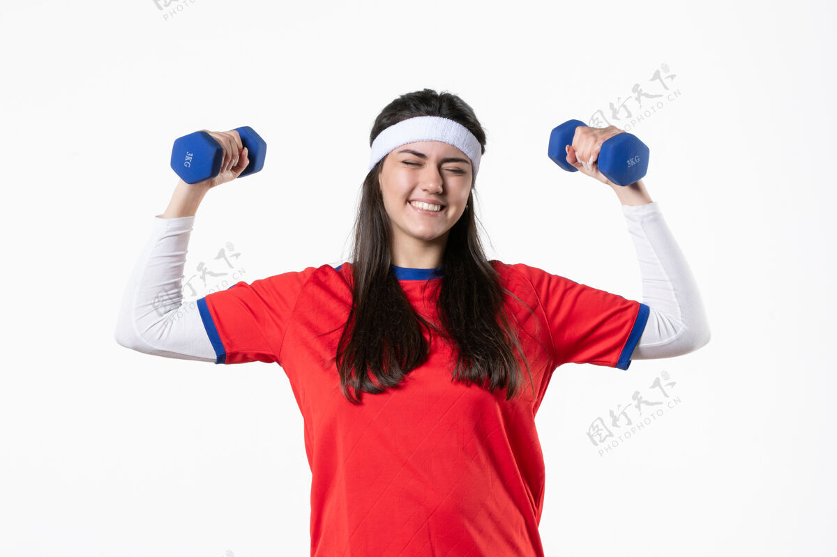人正面图快乐的年轻女性穿着运动服 用哑铃锻炼身体青年工作青少年