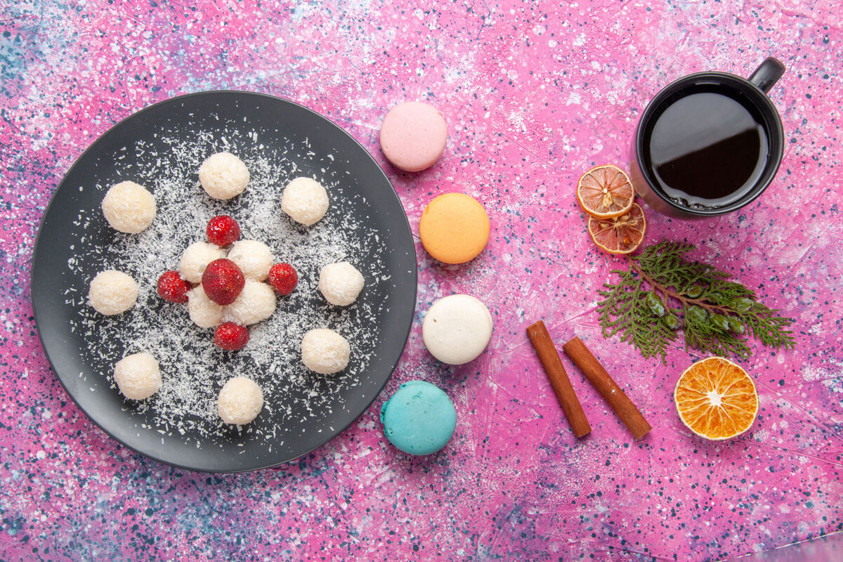 顶视图俯瞰美味的椰子糖甜球与法国马卡龙在粉红色的表面麦卡龙糖可口