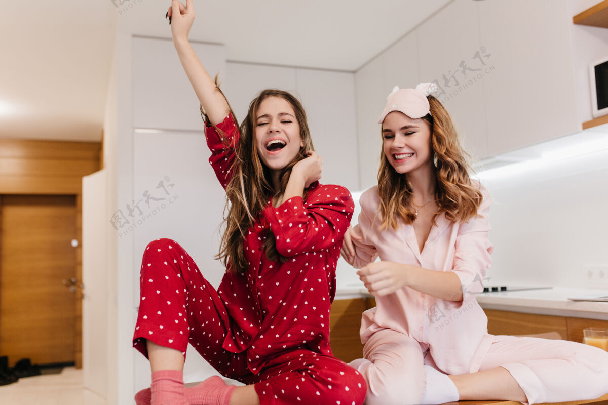 卧室热情的女孩穿着粉红色的袜子和明亮的睡衣摆出愉快的姿势华丽的年轻女士在家里度过早晨的室内肖像迷人睡衣休闲