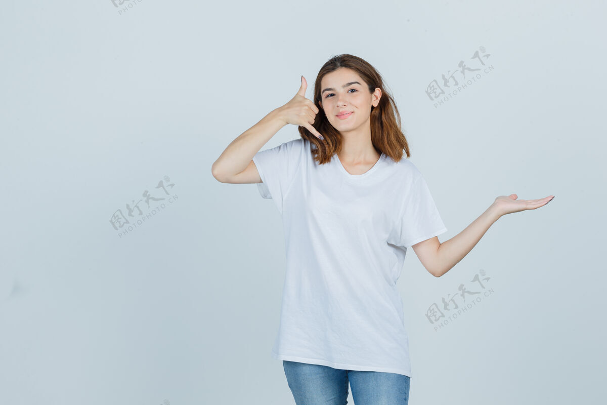 女孩一位年轻女士在展示手机手势的同时 还假装拿着一件t恤 牛仔裤 看上去很自信正面图假装自然亚洲人