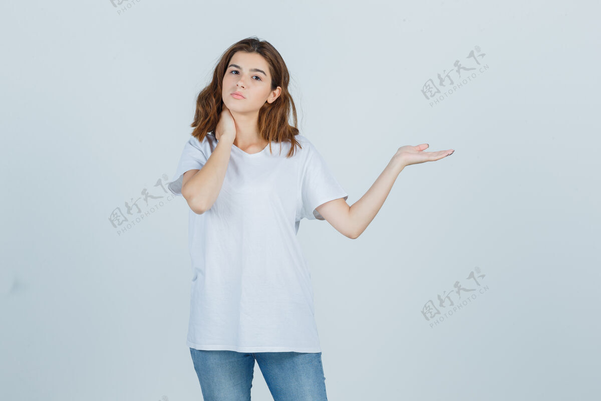 皮肤一位穿着t恤 牛仔裤的年轻女士假装在展示什么 手放在脖子上 看起来很自信女士女性新鲜