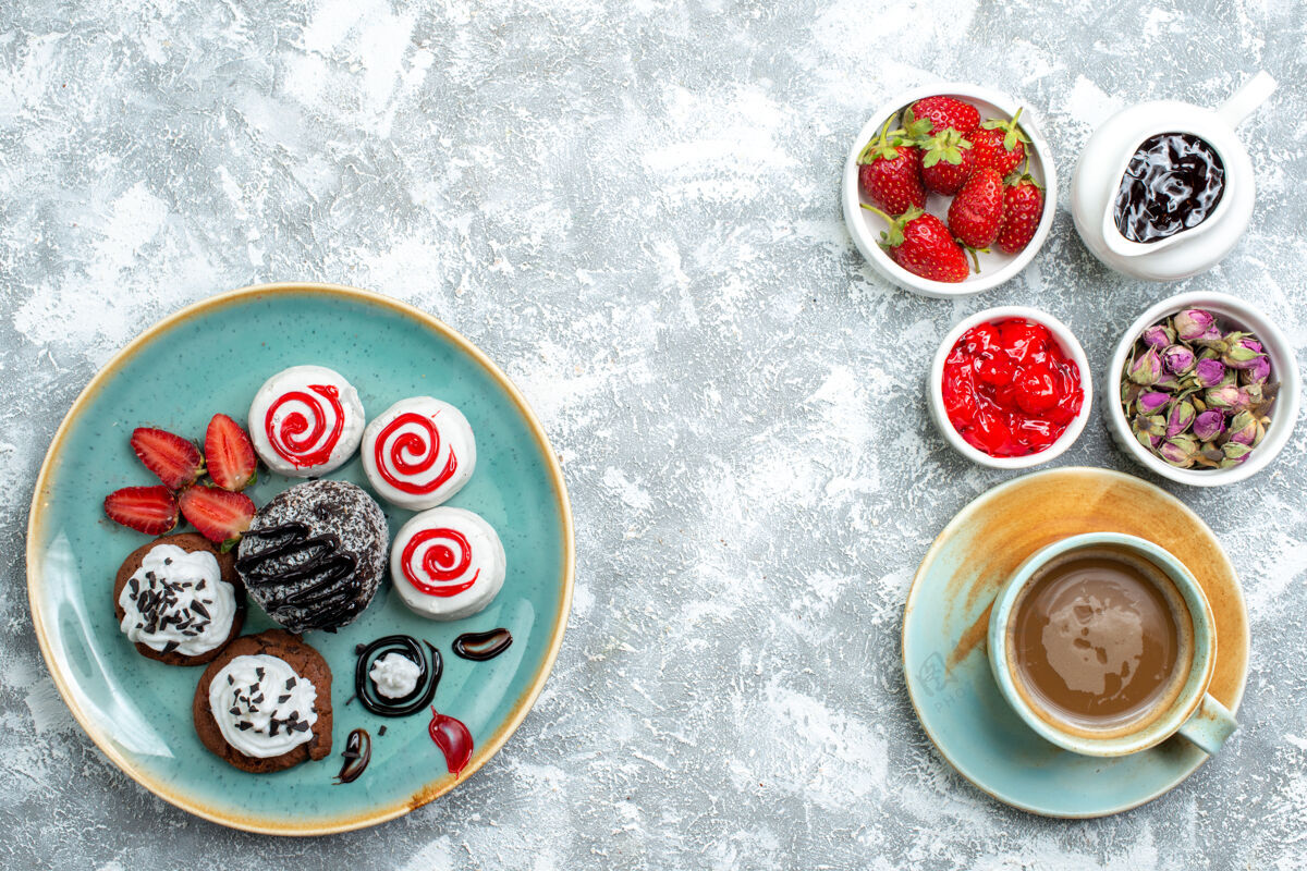 餐俯视图甜美的小蛋糕和水果和一杯咖啡的白色背景馅饼甜饼干饼干糖蛋糕生的饼干派