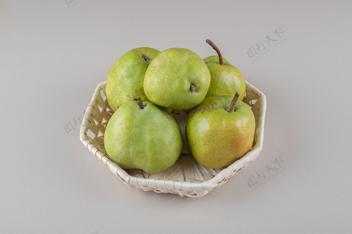 美味一捆梨放在大理石上的白色篮子里新鲜配料健康