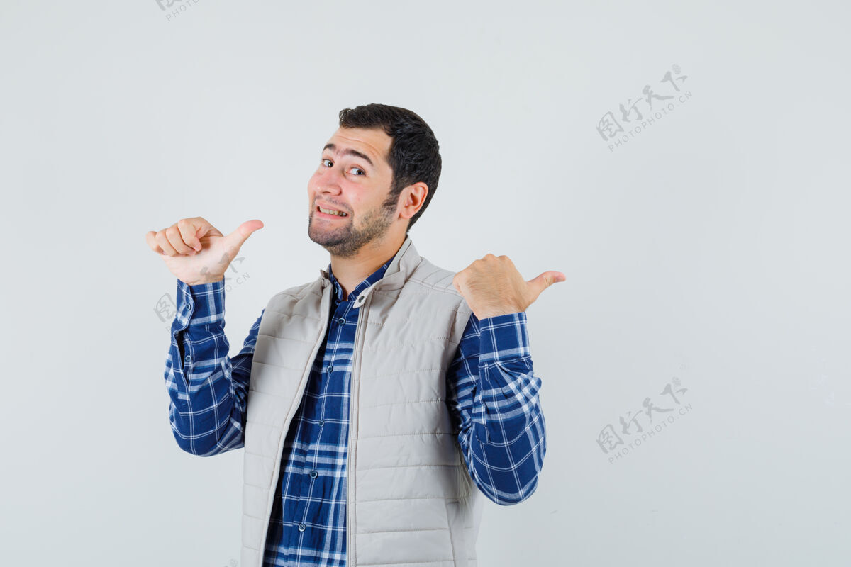 肖像年轻的男性指着背后的衬衫 无袖夹克 正面视图年轻人休闲手