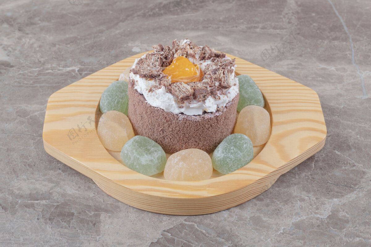 甜点在大理石上的木盘上围着一个小蛋糕做肉酱果酱甜点烘焙