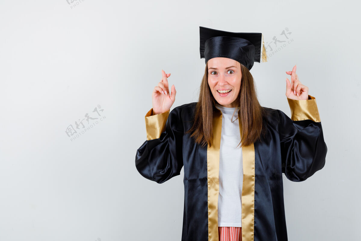 交叉身着学院服的年轻女毕业生举手投足学术漂亮人