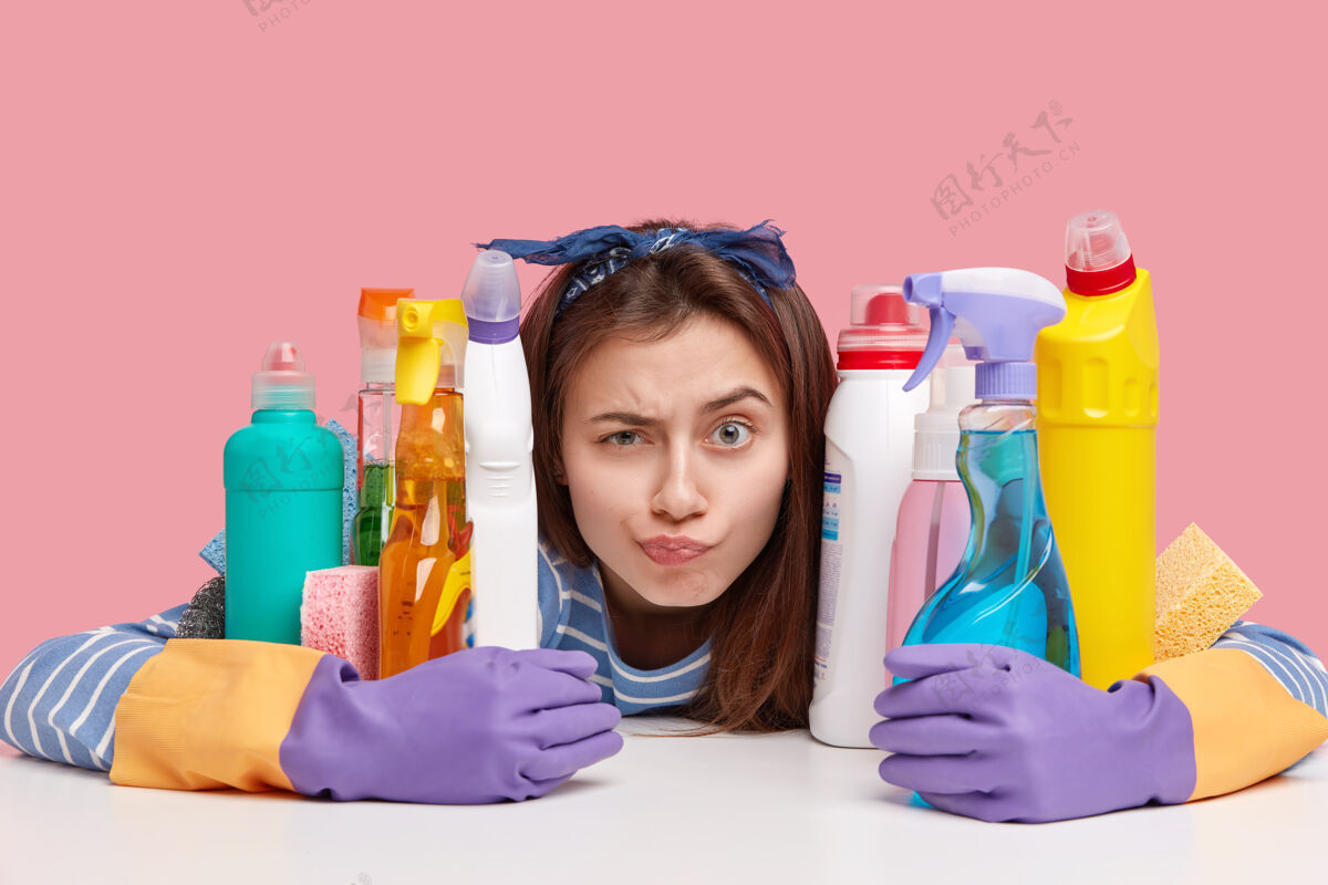 瓶子坐在清洁用品旁边的年轻黑发女人肖像产品女性