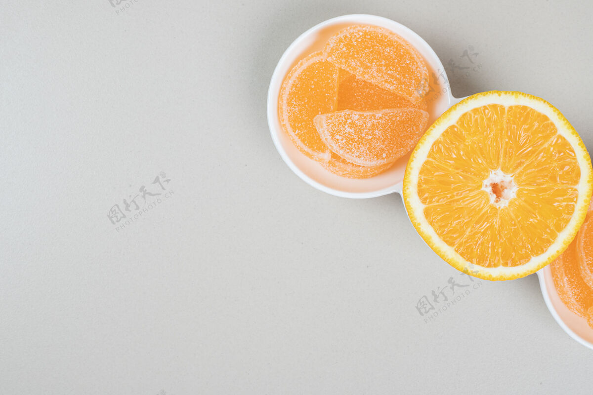 明胶橘子片和果冻糖放在白色盘子里新鲜美味果冻