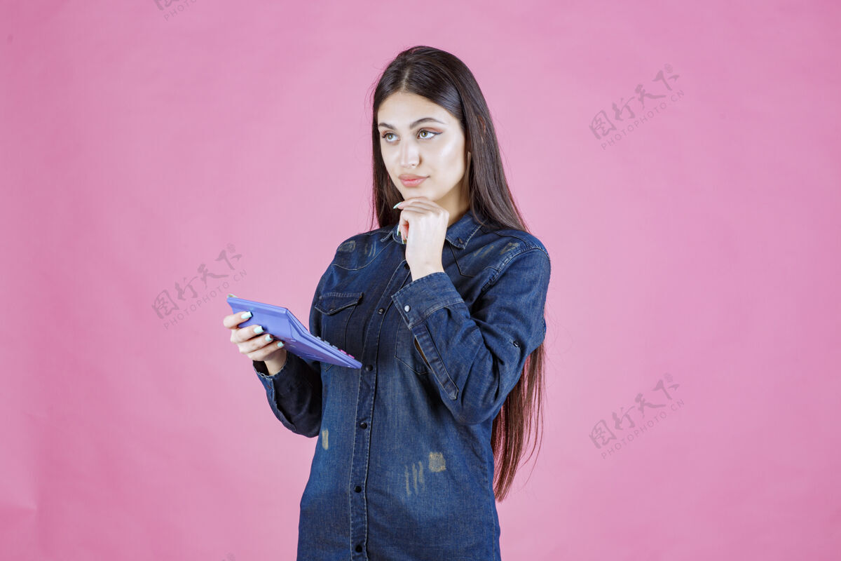 聪明拿着蓝色计算器思考的年轻女子工人数学金融