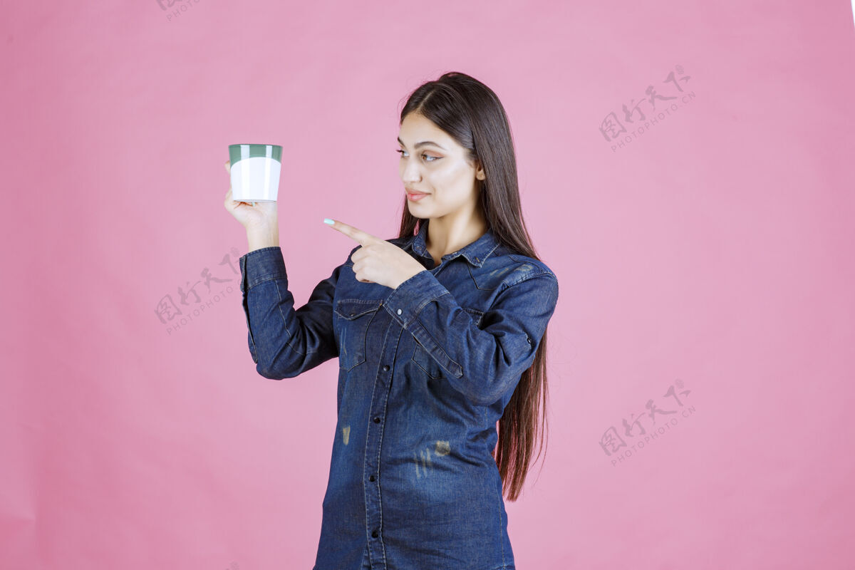 年轻人拿着咖啡杯指着它的年轻女人晋升女性工人