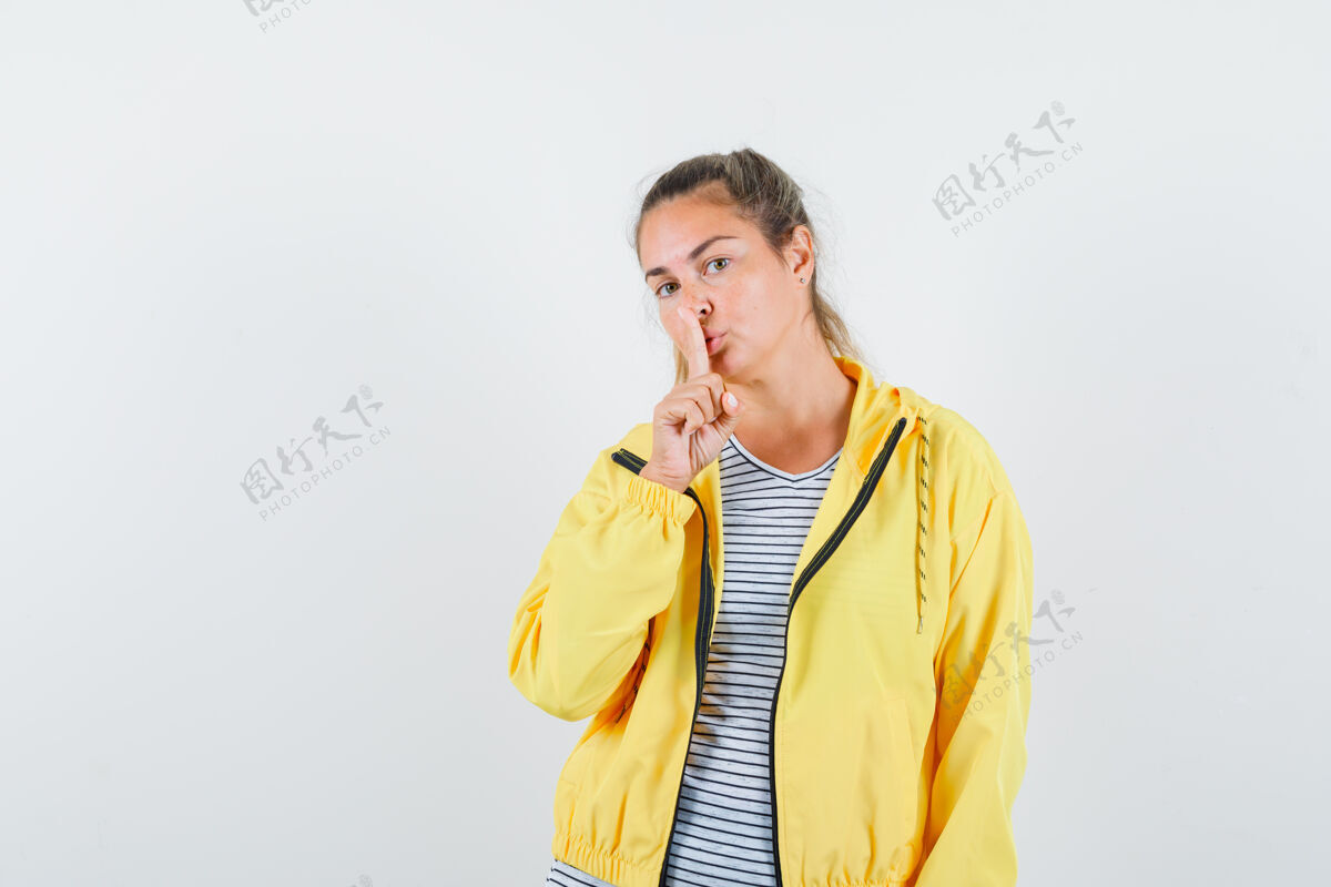 焦点金发女郎身穿黄色棒球服和条纹衬衫 表现出沉默的姿态 看起来很专注衬衫自然健康