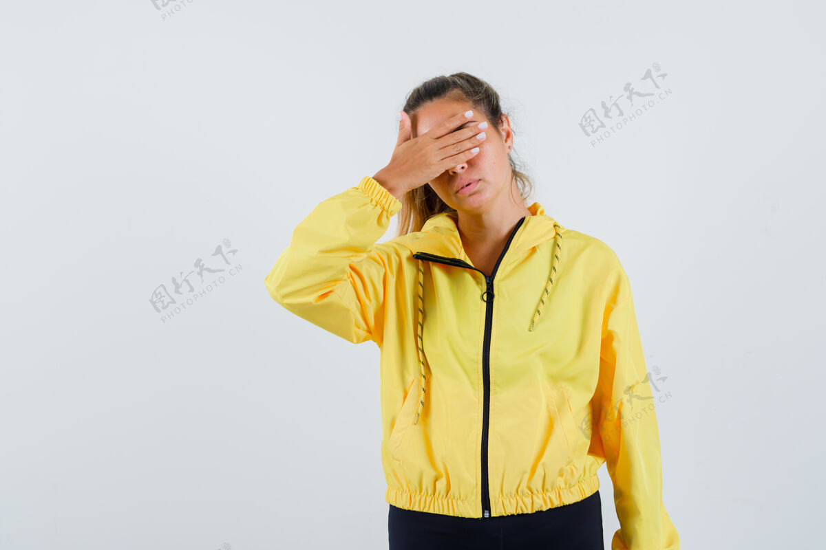 人穿黄色雨衣的年轻女子用手捂住眼睛 看上去很无聊脸女人雨衣