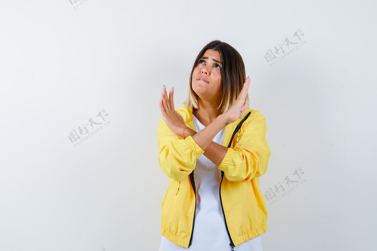 人年轻女孩双臂交叉 在白色t恤 黄色夹克衫上做着没有任何标志的手势 看上去很担心 前视图护理交叉担心