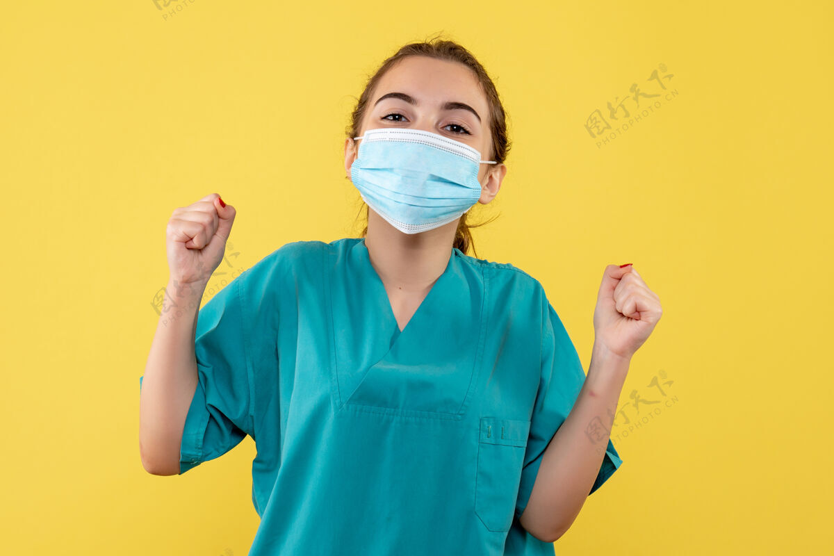 女人正面图女医生穿着医用衬衫 戴着口罩欢呼雀跃 病毒大流行制服covid-19健康冠状病毒医学女医生大流行