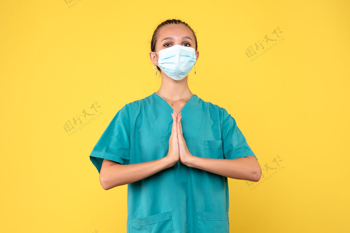 医疗前视图穿着医用衬衫和面罩的女医生祈祷 大流行医疗保健护士病毒covid-19医院肖像妇女女医生