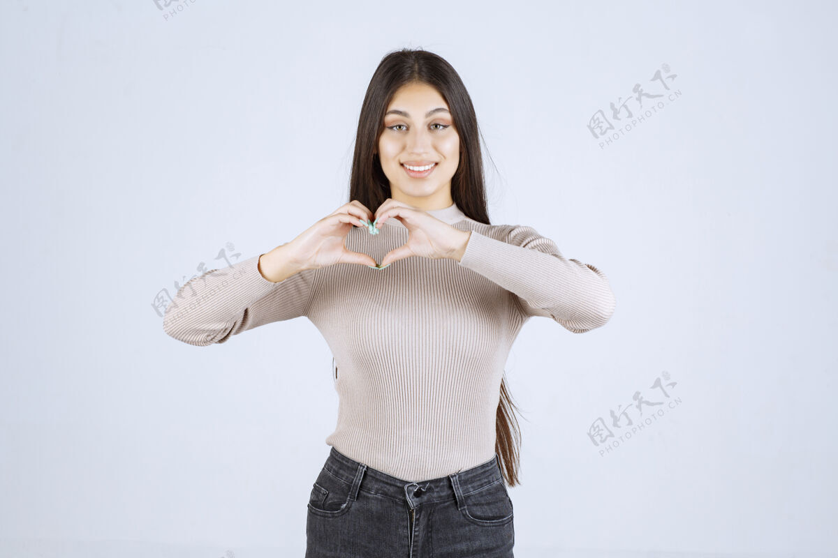 浪漫的穿灰色衬衫的女孩向她的粉丝们送去爱吹工作人员休闲