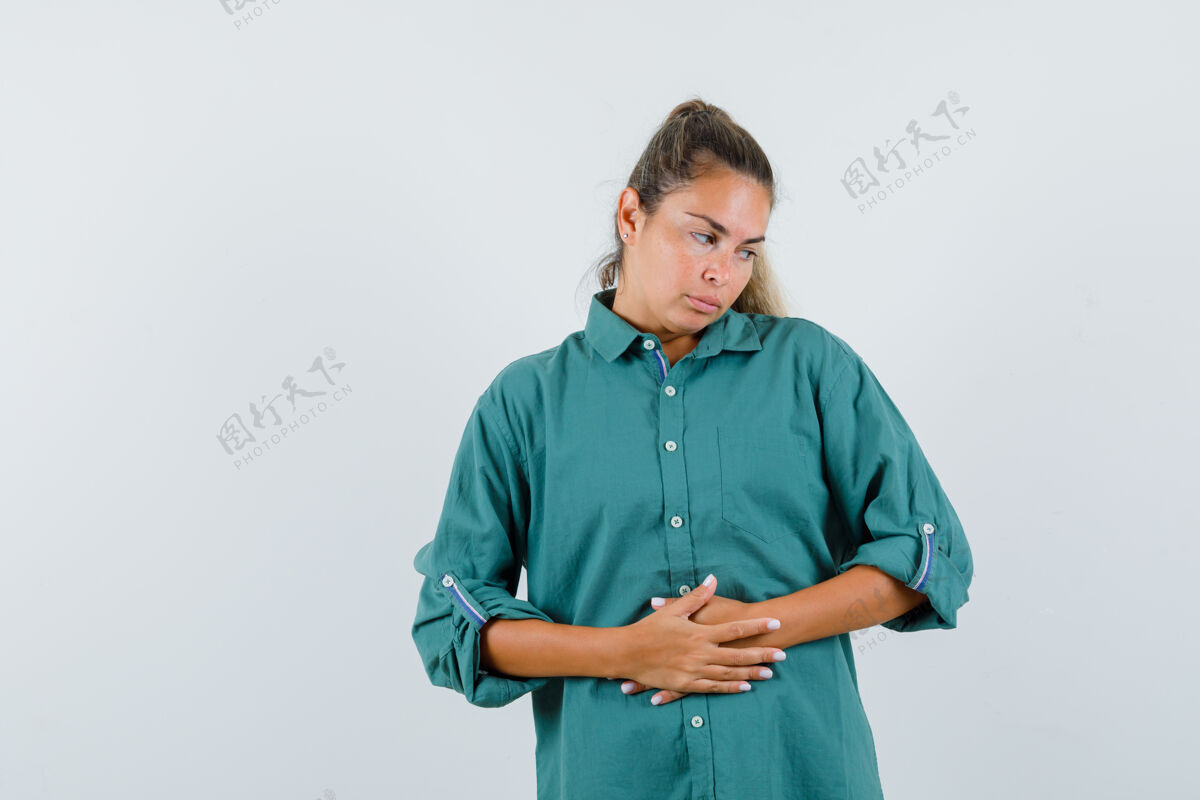 成人穿蓝衬衫的年轻女子手放在肚子上 看起来很乏味人自信年轻