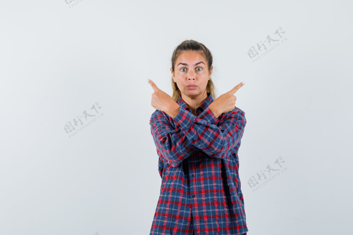 人穿格子衬衫的年轻女子指着不同的方向 神情严肃衬衫成人脸