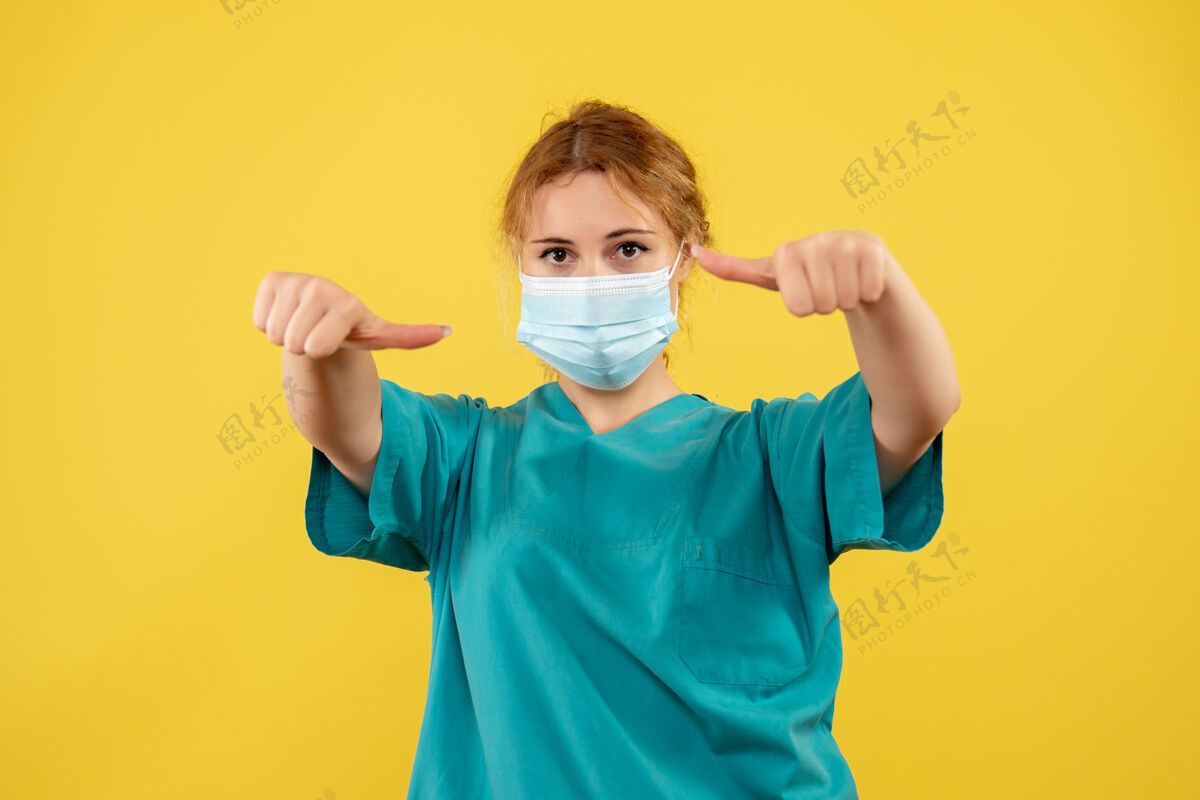 人黄墙上年轻女医生穿着医疗服 戴着口罩的正面图西装医疗成人