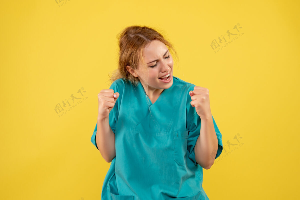 人黄色墙壁上 女医生穿着医用衬衫欢呼雀跃女医生前面情绪