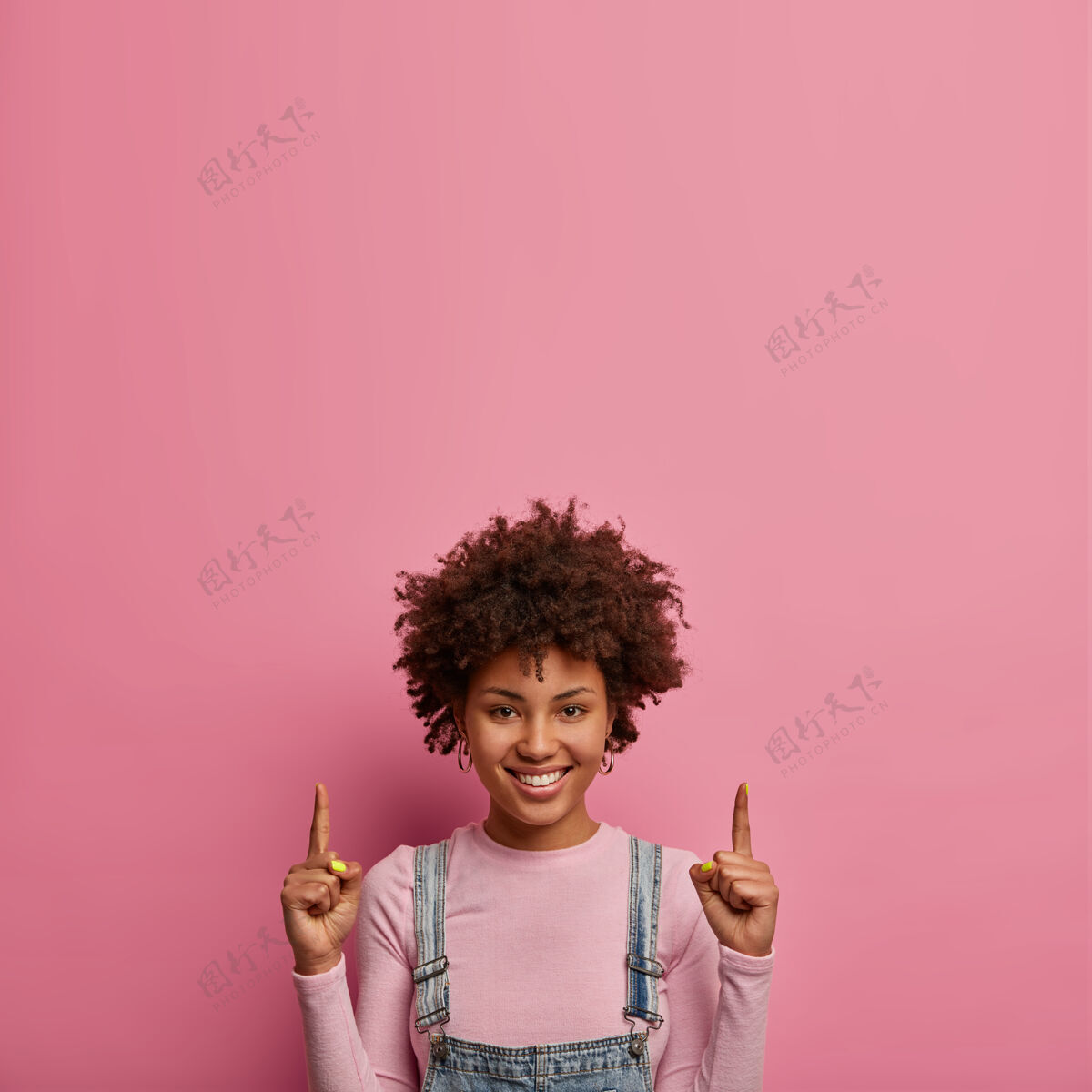 广告正黑皮肤的年轻女子用食指指着上面民族模特向上