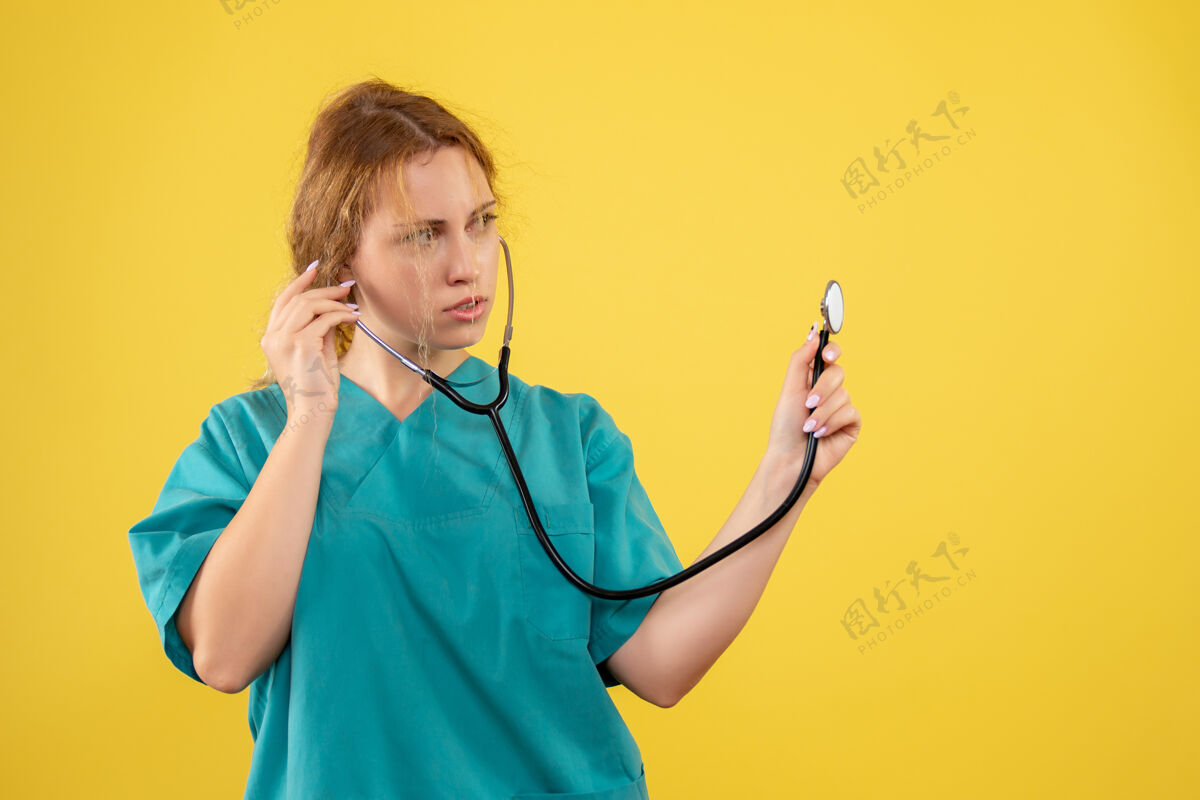 套装黄色墙上穿着带听诊器的医疗服的女医生的正视图仪器情绪医疗