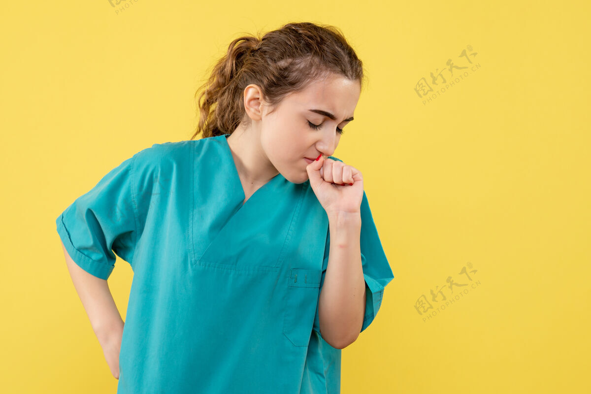 人黄色墙壁上穿着医疗服的女医生的正视图成人病毒女商人