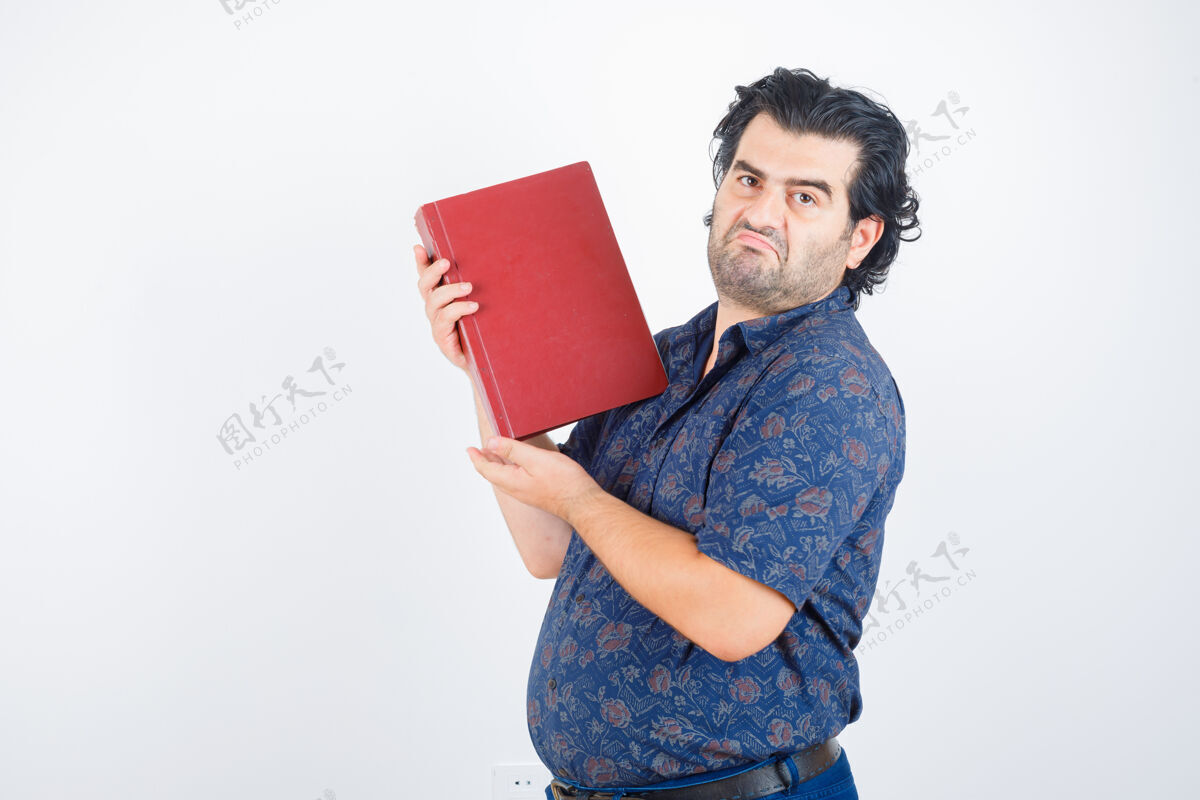 商务员中年男子拿着一本书放在胸前 穿着衬衫 神情犹豫不决 俯视前方麻烦发生人