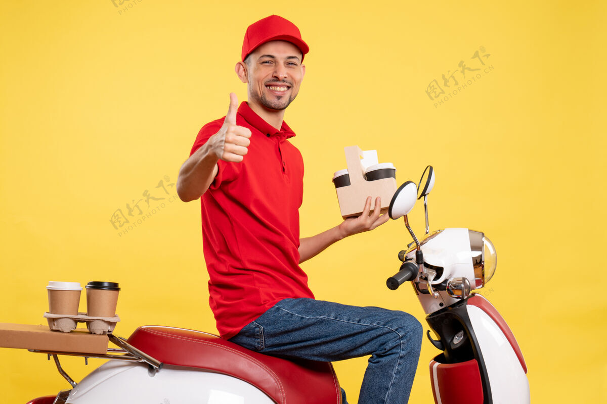黄色正面图身着红色制服的男性快递员 穿着黄色服务颜色制服的咖啡 骑着送货员自行车人红色前面