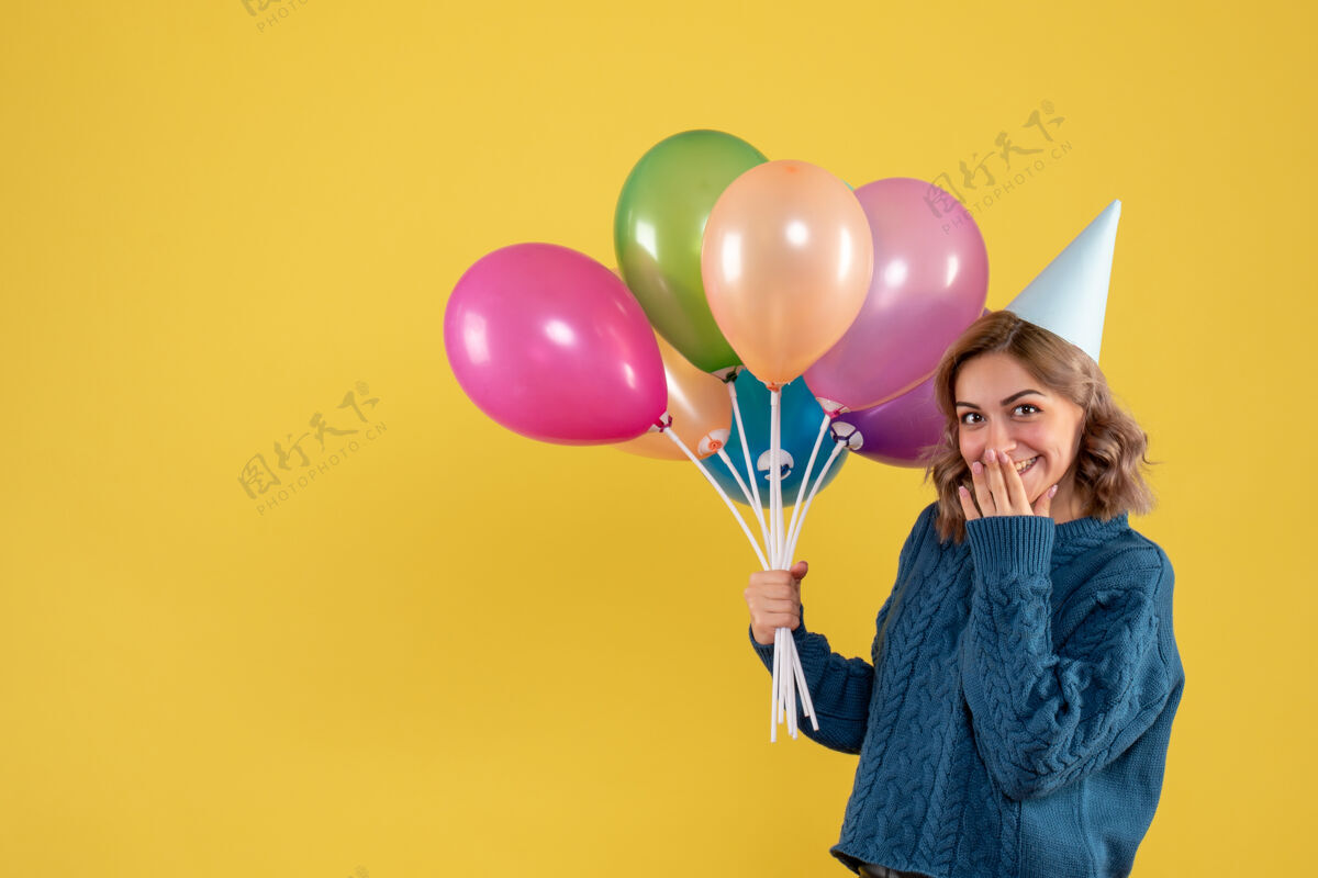 气球正面图：带着彩色气球的年轻女性氧气一年生日