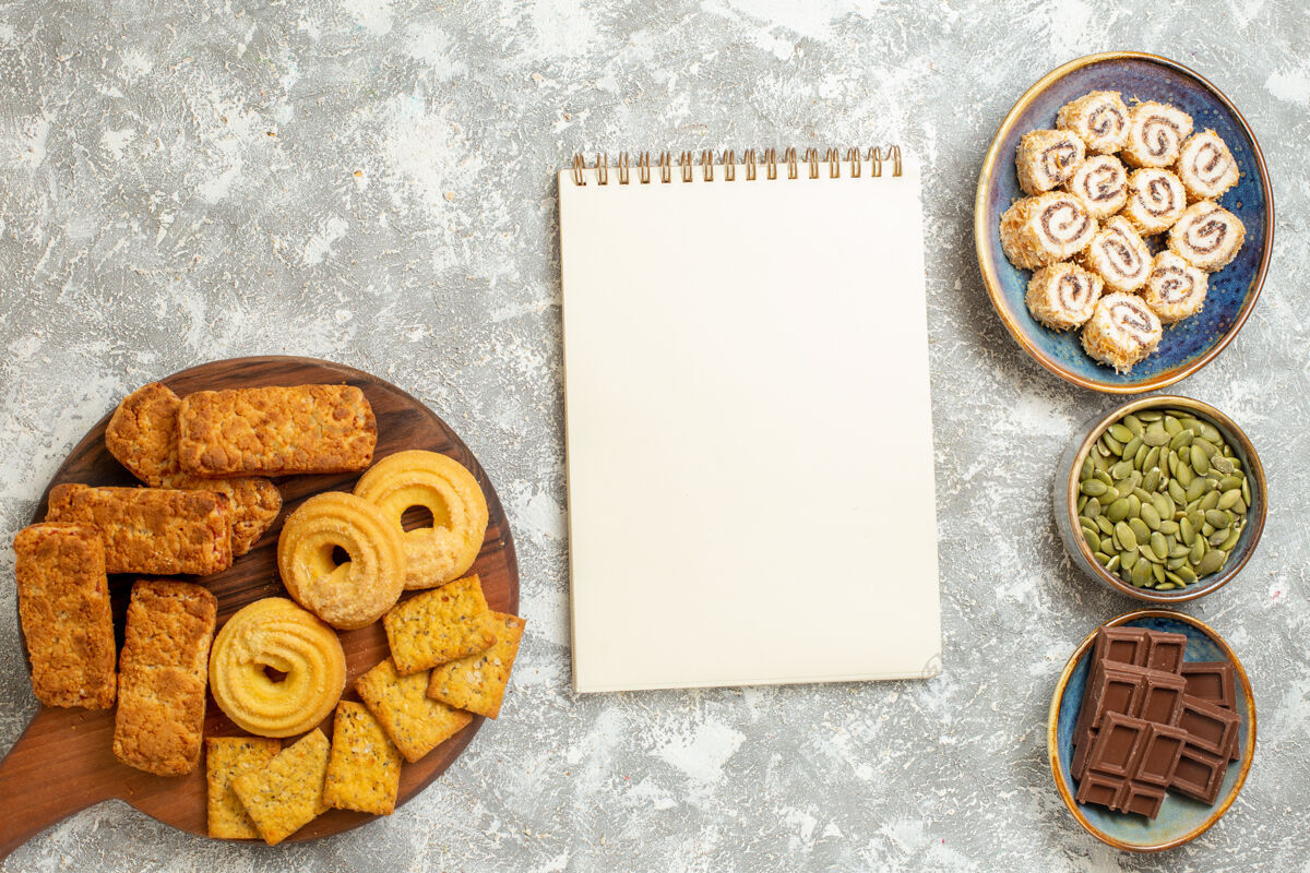 饼干在浅白色的背景上俯视美味的蛋糕和糖果和饼干旧的古董邮票