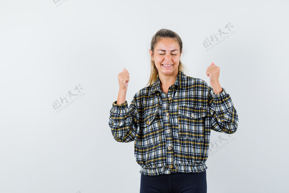 女士穿着格子衬衫的年轻女士展示着赢家的姿态 看起来很开心正面图获胜者肖像休闲