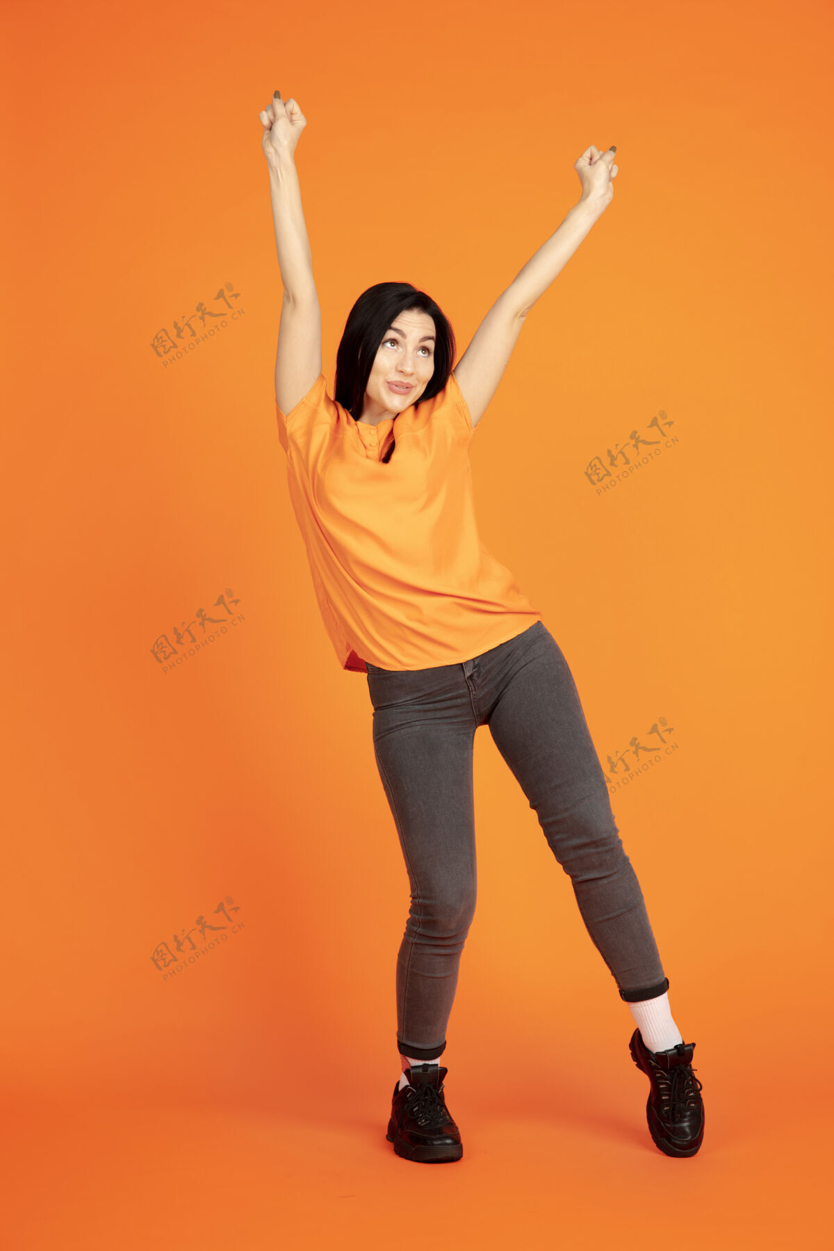 一半橙色工作室背景上的白人年轻女子肖像衬衫现代背景