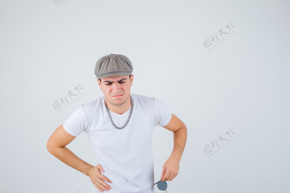 拉美裔小男孩手放在腰上 穿着t恤 戴着帽子 看上去很痛苦正面图时尚冷静男孩