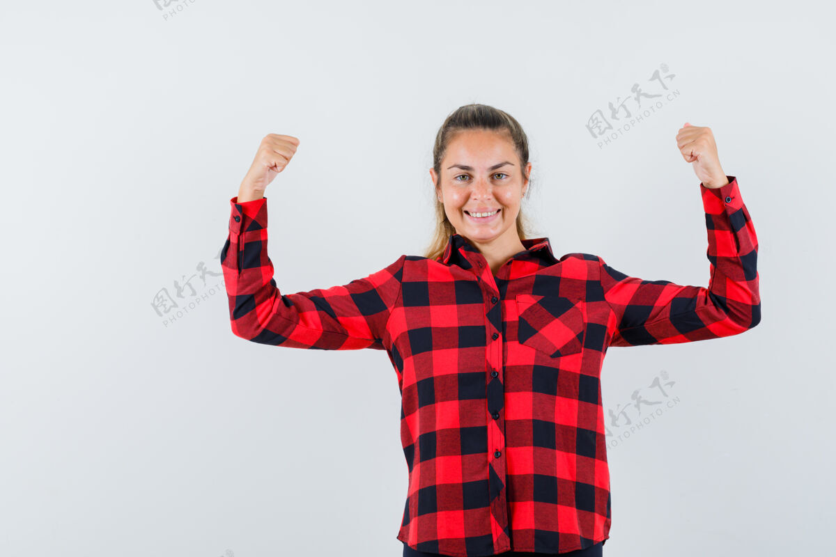 成人穿着休闲衬衫的年轻女士展示了赢家的姿态 看起来很开心 正面视图手势一个正面