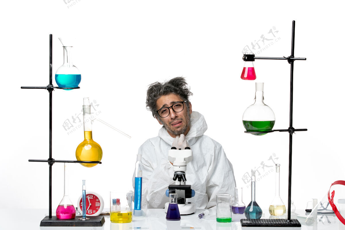 解决方案前视图穿着特殊防护服的疯狂男科学家围坐在桌子旁 用白色背景疾病冠状病毒实验室科学病毒的解决方案实验室病毒瓶子