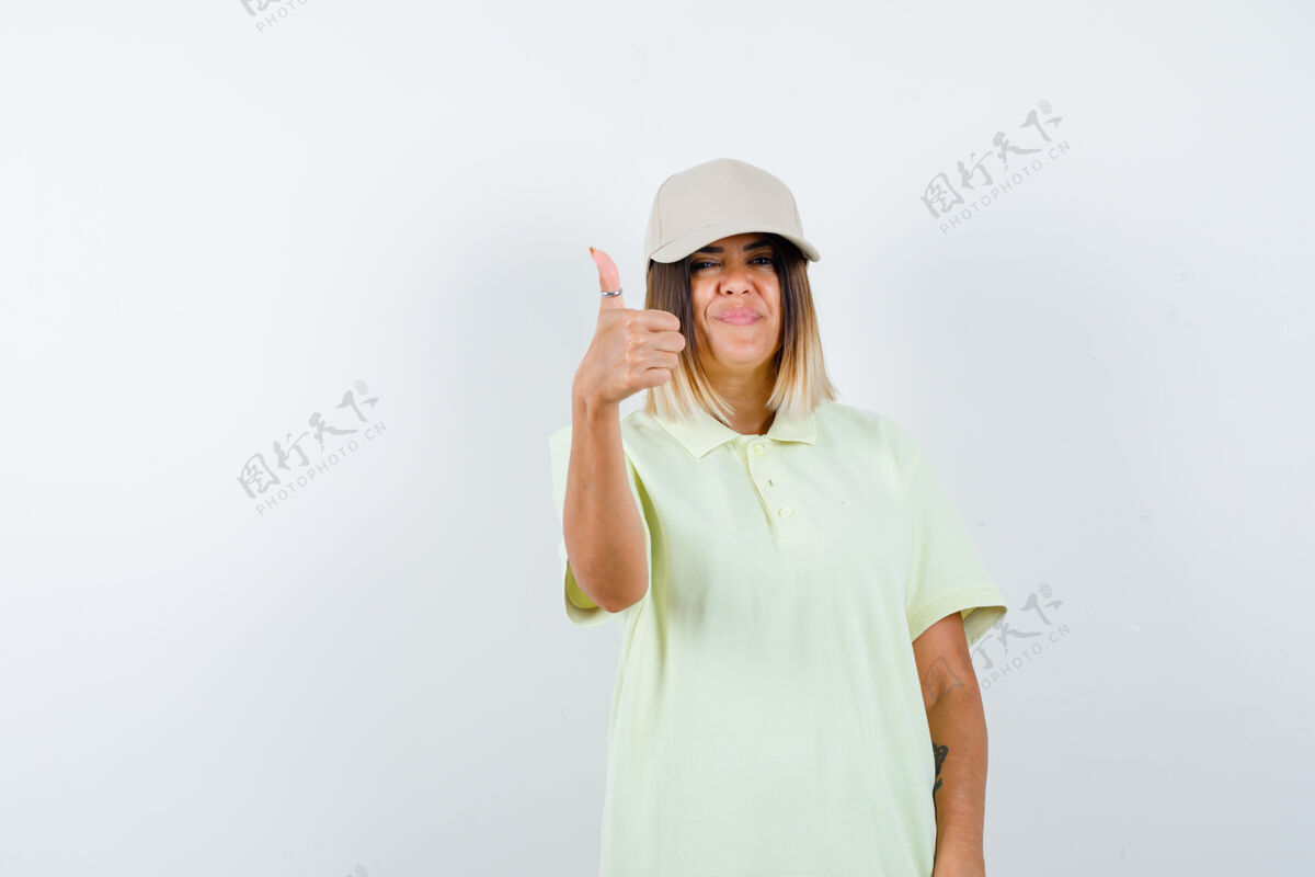 水疗年轻女性穿着t恤 戴着一顶大拇指向上的帽子 看上去很开朗 正面朝下年轻眼睛健康