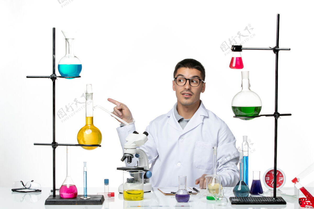 医学前视图穿着白色医疗服的男性化学家坐在白色背景病毒实验室共患疾病科学的解决方案医院医生罐子