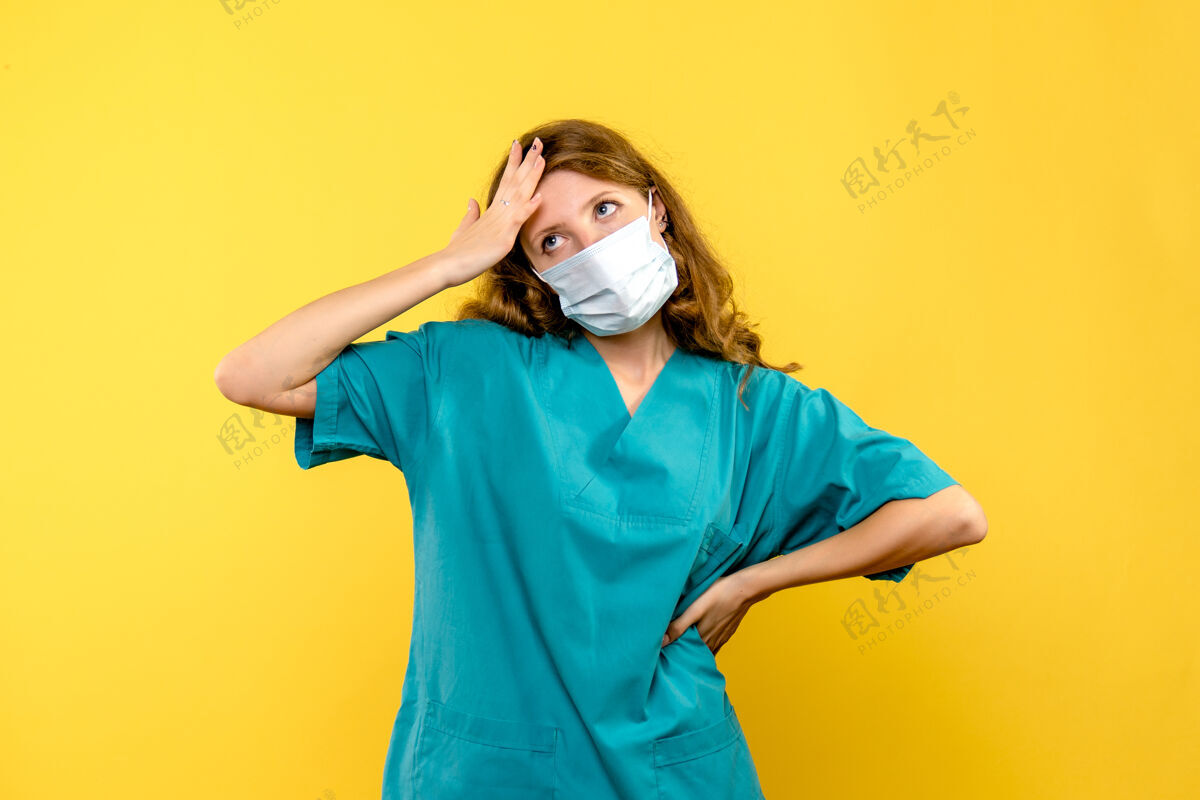 快乐戴着面具的女医生正对着黄色的墙上思考黄色模特专业